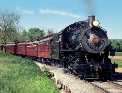 Freight Train With Red Engine Pulling Out Of Station Stock Photo