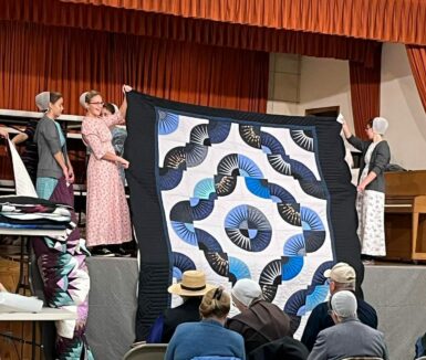 Girls holding quilt