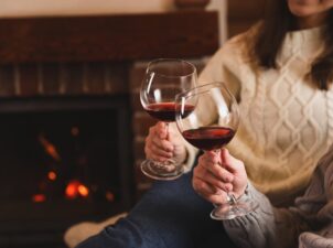 Couple drinking wine by the fire during their romantic getaways in Pennsylvania